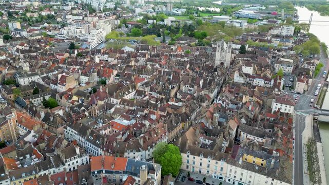 Aerial view of the Chalon Cathedral amidst a sea of terracotta rooftops and lush greenery, Chalon-sur-Sa&ocirc;ne, France.