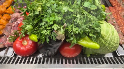 Fresh vegetables and meat display with parsley, tomatoes, and peppers