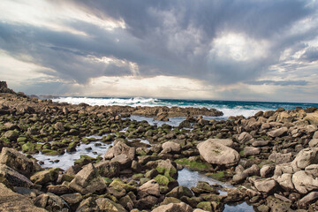 Moss-covered rocks meet the Atlantic Ocean on the C&iacute;es Islands, Galicia, Spain. A rugged and serene coastal scene, perfect for nature, texture, and travel-related themes.