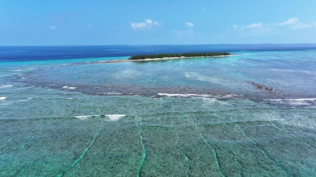 Aerial view of turquoise waters surrounding an island and reefs, a stunning contrast of blues and greens creating a serene seascape, Naavaidhoo, Haa Dhaalu City, Maldives.