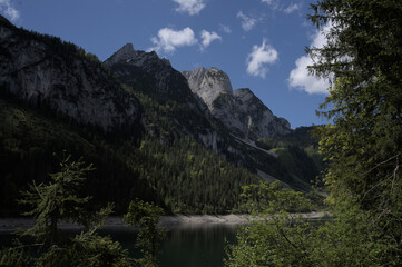 Mountain landscape showcasing lush greenery and clear blue sky during midday in a serene natural setting