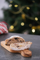 A delicious looking baked treat presented on a wooden board, showcasing various nuts and dried fruits. Christmas stollen. Traditional German sweet bread.