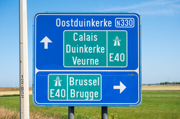 Road sign to Oostduinkerke and the E 40 highway in Avekapelle, Veurne, Belgium
