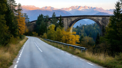 Fototapeta premium A narrow road surrounded by vibrant autumn foliage curves towards a stunning mountain backdrop in Italy, capturing the beauty of the landscape during the calm of summer twilight