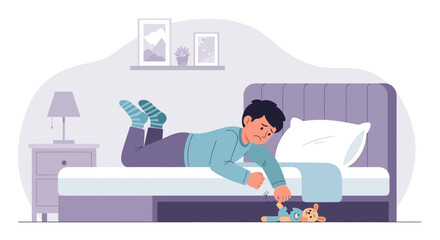 Sad boy trying to get his torn teddy bear from under the bed in his room