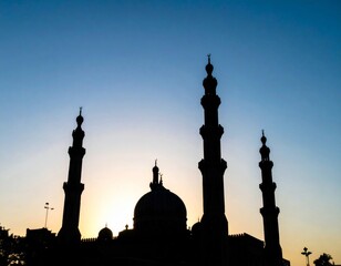 Silhouette of Mosque Against a Light Blue Sky at Sunset Featuring Minarets