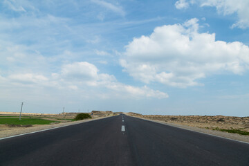 Lonely road carves through rugged desert of Gheshm Island under a moody sky—where isolation meets the allure of wild landscapes.