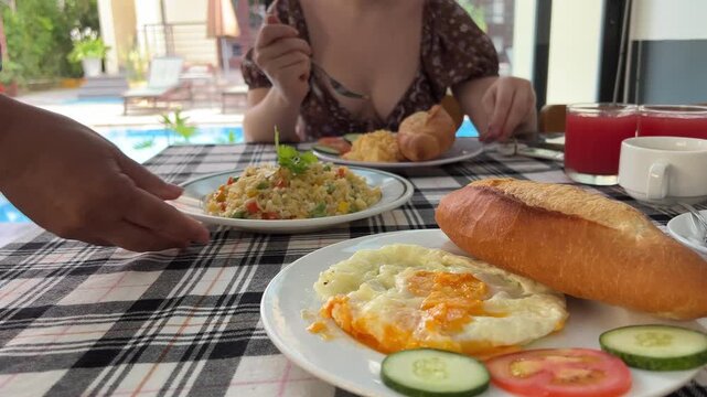 buns ban me vietnamese food cafe breakfast in hotel resort Morning food on villa near blue swimming pool. Poolside table, healthy breakfast and fruit plate by resort pool. Tropical luxury lifestyle