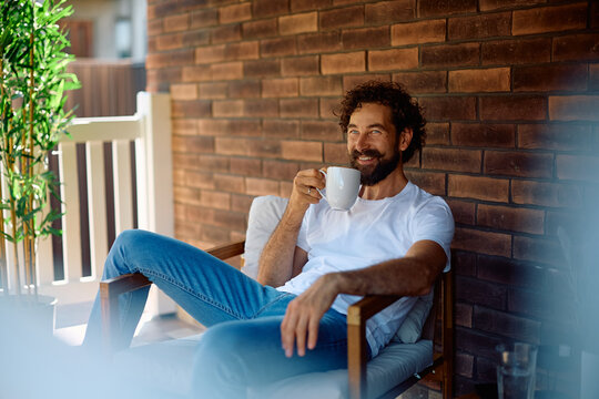 Happy man enjoying in cup of coffee on porch. - Powered by Adobe