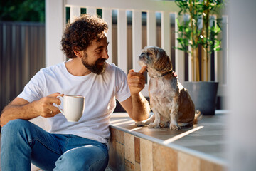 Happy man enjoying with his dog on porch.