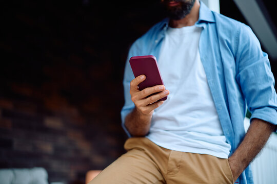 Close up of man using smart phone on porch. - Powered by Adobe