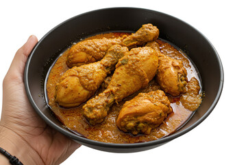 A bowl of golden brown chicken drumsticks in gravy held by a hand ready to be served and eaten on transparent background