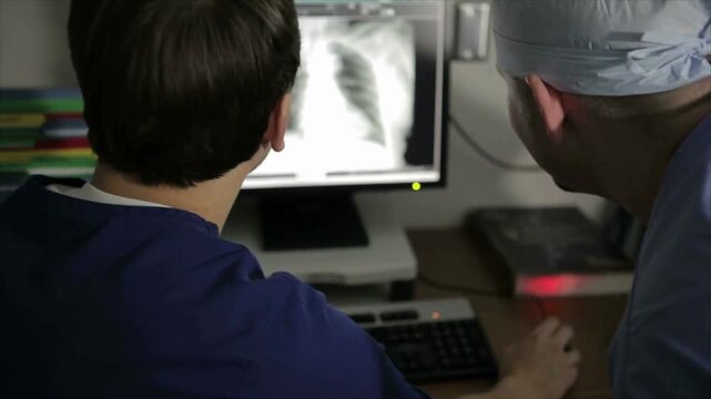 Radiologic Technologists Analyzing X-Ray Image on Hospital Monitor