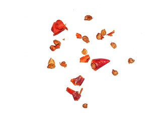 Scattered sliced red chili peppers with seeds and chopped pieces with seeds scattered around on a white background. Pile of crushed red chili peppers or paprika, perfect for spicy food concepts.