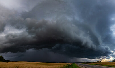 WEATHER Vertical Picture Dramatic black rain clouds over fields and country road