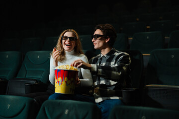 Couple enjoys popcorn while watching a movie in a theater