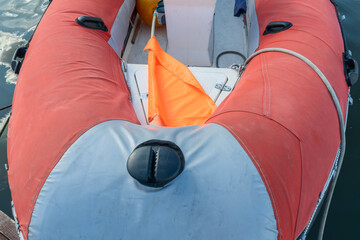 Inflatable rescue boat equipped with steering console. Safe haven for exploration a red inflatable boat rests peacefully at the pier ready to embark on new adventures.