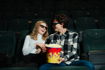 Couple enjoys a movie date while sharing popcorn in a theater
