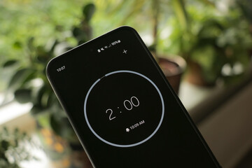 Phone stopwatch with a black 2-minute timer to be productive or studio with a green, plants background