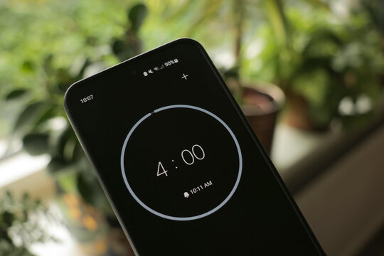 Phone with a black and white 4-minute timer to study with the pomodoro method on a green, plants background