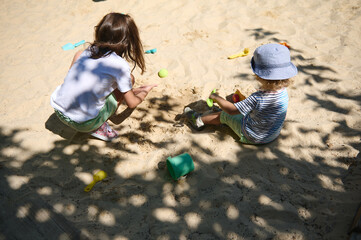 Children Playing Happily in a Sandbox at a Sunny Park Playground During Summers