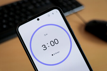 Phone white 3-minute timer to study with pomodoro method on laptop keyboard, study business background