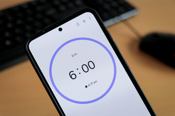 Phone white 6-minute timer to study with pomodoro method on laptop keyboard, study business background