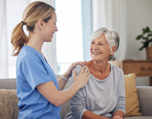 Obraz premium Kind nurse comforts senior woman with hand on shoulder in her home during daytime