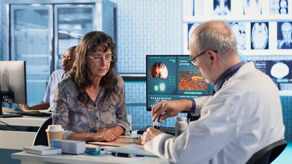 Fototapeta premium Old physician recommending vitamins and painkillers on medical insurance, writing prescription with instructions and the right dosage of medicine. Healthcare services and pharmaceutics. Camera B.