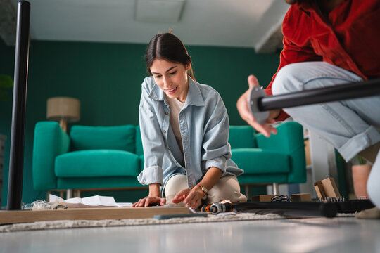Couple assembling furniture together at their new apartment