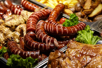 Assorted grilled meats including sausages, chicken, and beef, garnished with fresh lettuce, served on a platter, showcasing a delicious and appetizing feast for gatherings