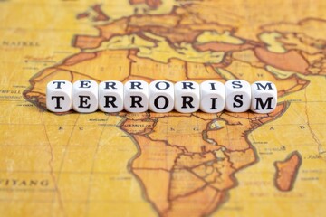Wooden blocks with the text, TERRORISM, on the background of world map.