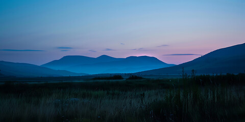 Twilight over rolling hills with a gradient sky transitioning from blue to pink
