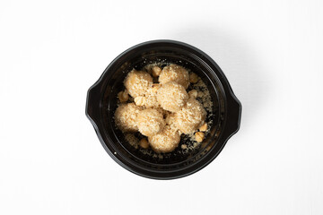 Homemade sweet hazelnut balls covered in crumbs, served on a plate. Isolated on white background