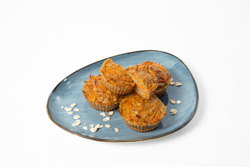 Homemade carrot and oat muffins served on a plate with oat flakes
