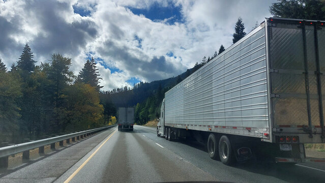Two semi trucks rolling down the road.