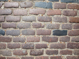A stone cobbled street pattern. With red and grey stones.