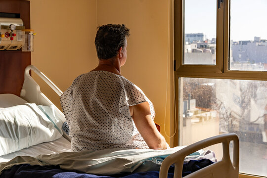 Hospitalized man gazing at the city skyline from his room