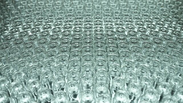 empty injection vials pharma grade injection glass vials to be filled with medical chemical drugs in an injection manufacturing line inside a healthcare pharma industry factory. injection vaccine vial