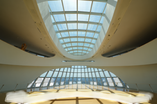 Modern architectural interior with curved walls expansive glass ceiling and panoramic city views isolated on transparent background