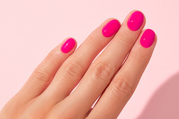 Close up beautiful womans hand with pink nail design. Manicure, pedicure beauty salon concept