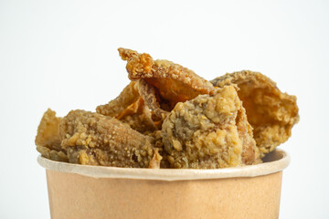 Keripik kulit ayam (Chicken skin chips) in a paper bowl. Indonesian street food.