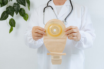 One elderly doctor holds a new colostomy bag.