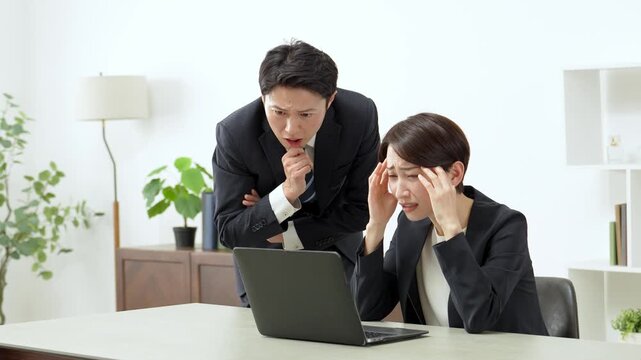 困った表情でパソコンを使うビジネスパーソン