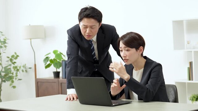 困った表情でパソコンを使うビジネスパーソン