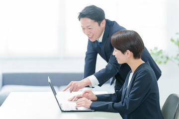 オフィスでパソコンを使って研修を行うビジネスパーソン