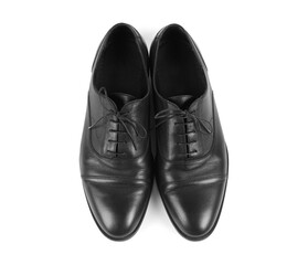 Pair of black leather shoes on white background, top view
