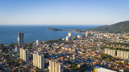 Fototapeta premium Aerial view of Penha, Brazil, showing dense urban growth and high-rise buildings by the coast.