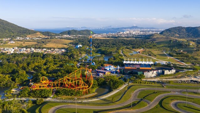 Aerial view of Beto Carrero World with roller coaster and cityscape of Balneário Camboriú in the background.