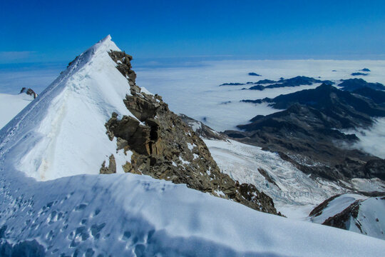 Alps mountains snow ridges view of Monte Rosa massive. Lyskamm, Pollux and Castor summits above the clouds stunning landscape mountains view. Alps high attitude extreme terrain climbing and glacier